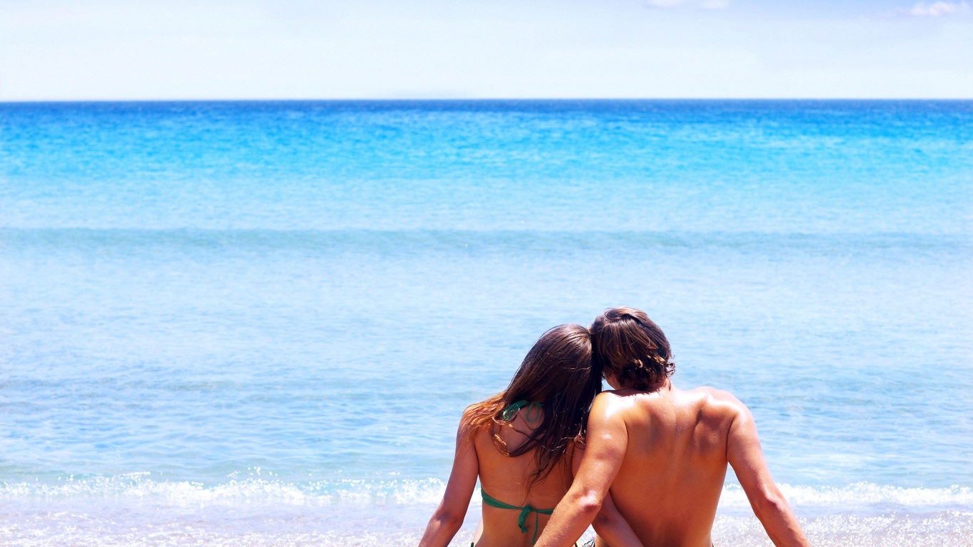пара сидит на берегу моря