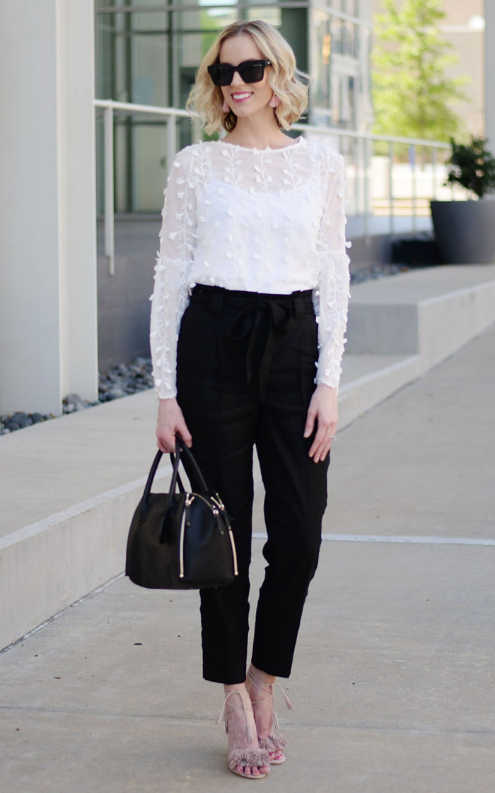 Черные брюки с белой кружевной блузкой и черной сумочкой